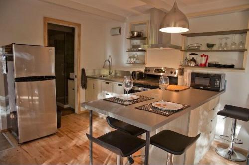 梅戈格Le Cocon Orford Domaine Cheribourg的厨房配有冰箱和桌椅