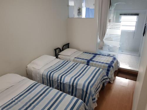 圣保罗Av. Paulista Trianon MASP的一间设有三张床及条纹床单的客房