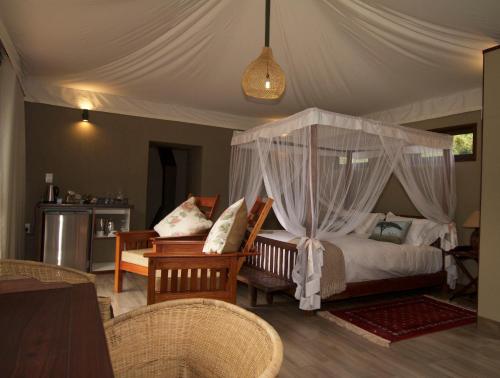 威尔吉旺登禁猎区Inzalo Safari Lodge的一间卧室配有一张带天蓬的床