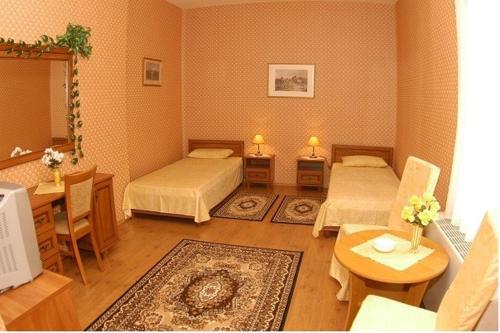 德布勒森Peron Panzió的客房设有两张床和一张桌子,