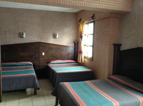 乌鲁阿潘瑞吉斯酒店的酒店客房设有三张床和窗户。