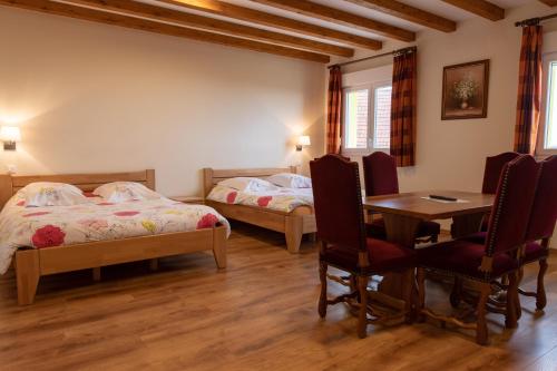 Heiligenstein科勒维内驿站酒店的一间卧室配有两张床和一张桌子及椅子