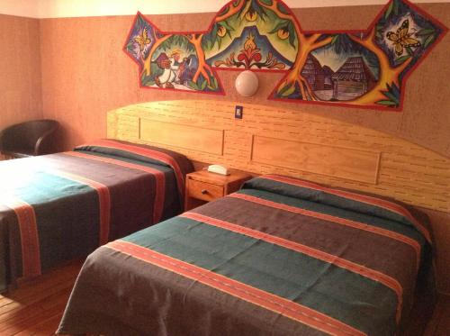 乌鲁阿潘瑞吉斯酒店的一间卧室设有两张床,墙上挂着一幅画