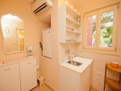 巴斯卡Rooms Nadica的一个带水槽和镜子的小厨房