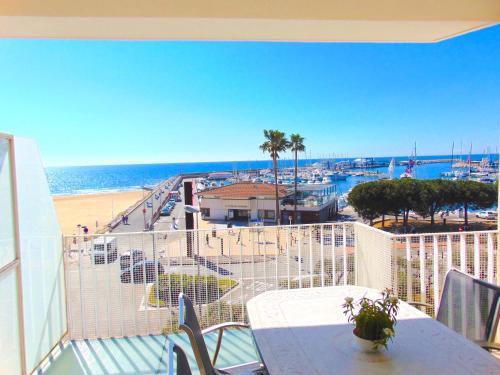 坎布里尔斯沃拉马尔公寓的阳台配有桌子,享有海滩美景