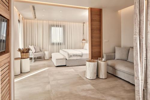 阿吉奥斯普罗科皮奥斯18 Grapes Hotel的一间卧室配有一张床、一张沙发和一把椅子
