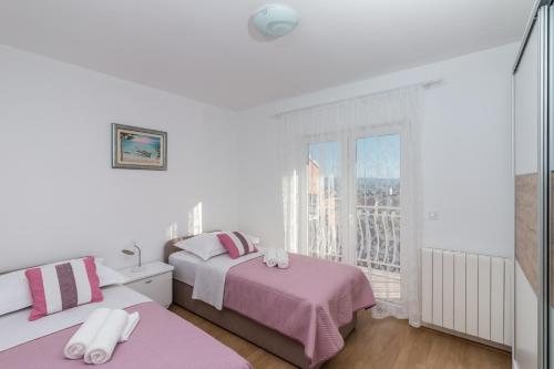 斯塔布鲁克Apartment La Mare的白色的客房设有两张床和窗户。