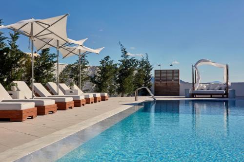阿吉奥斯普罗科皮奥斯18 Grapes Hotel的游泳池旁带躺椅的游泳池
