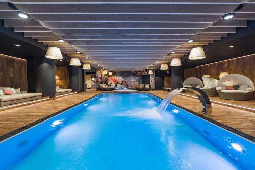 什恰夫尼察Szczawnica Park Resort & Spa的一座带水滑梯的酒店游泳池