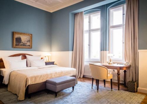 柏林柏林选帝侯大道亨利酒店的一间卧室配有一张床、一张书桌和窗户。