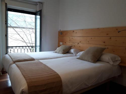 圣塞瓦斯蒂安桦木旅馆的卧室设有两张床和大窗户