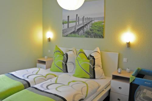 马林费尔德Ferienhaus Müritzidyll / EG-Appartement的一间卧室配有两张带绿色和白色枕头的床