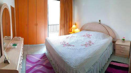 朱尼耶AlSaeed Residence的一间卧室配有一张床、一个梳妆台和一扇窗户。