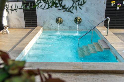 桑丹斯基Spa Hotel Spartak的配有带楼梯的热水浴池和水