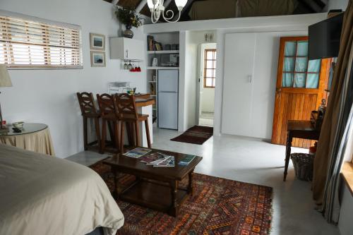 圣弗朗西斯湾Milkwood Way的一间卧室配有一张床铺和一张桌子,还设有一间厨房