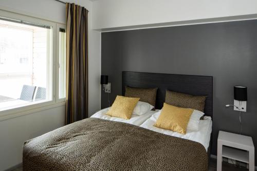 萨拉Holiday Club Salla Superior Apartments的一间卧室配有一张带黄色枕头的大床