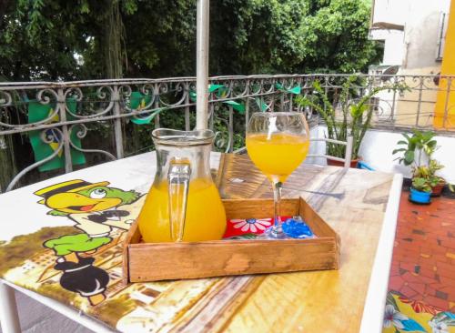 里约热内卢Hostel Recanto de Alegrias em São Cristòvão的一张桌子上装有一杯橙汁的木托盘