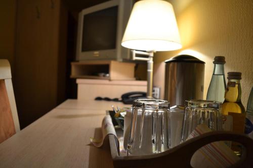 Großostheim兰德加斯托福霍克旅馆的一张桌子,上面有台灯和眼镜