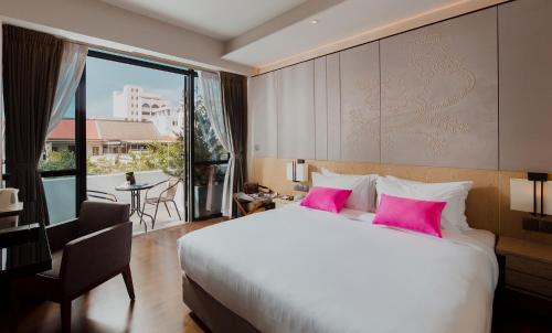 乔治市Victoria Garden Hotel的卧室配有一张带粉红色枕头的大床
