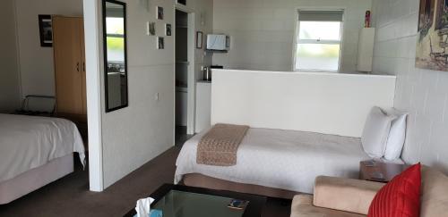 WhangaroaWhangaroa Lodge Motel的小房间设有床和沙发