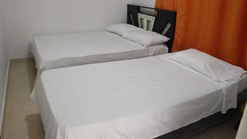 里奥阿查Apartamentos Arpushana的配有白色床单的客房内的两张床