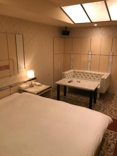 大阪Prime Hotel Fulula プライムホテル フルーラ的客房设有两张床、一张桌子和一张沙发。