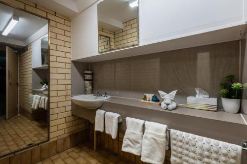 杰拉尔顿帆杰拉尔顿住宿酒店的浴室配有盥洗盆、镜子和毛巾