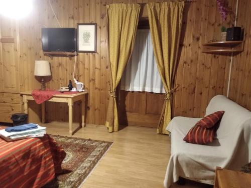 布勒伊-切尔维尼亚Baita Layet的带沙发、桌子和电视的客厅