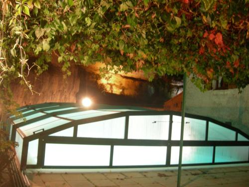 圣埃尼米耶Logis Hôtel restaurant Auberge de la Cascade的游泳池顶部有灯
