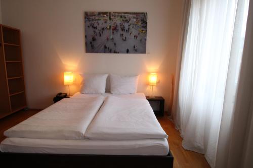 埃森洛伦茨酒店的一间卧室配有一张带两盏灯的大型白色床。