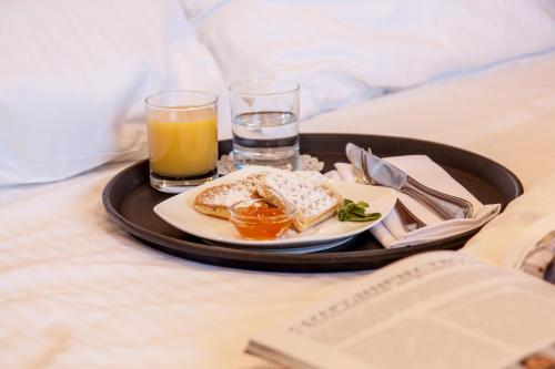 斯塔夫罗波尔斯塔夫罗波尔欧洲酒店的床上装有一盘食物和饮料的托盘