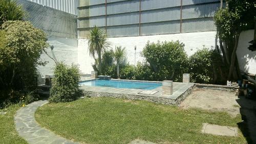 圣卡洛斯-德巴里洛切Universal Traveller's Hostel的一座游泳池,位于一座建筑旁的院子内