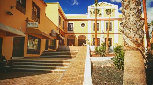 圣米格尔德阿沃纳Sweet Home San Blas的前面有楼梯和棕榈树的建筑