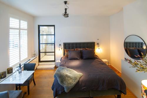 赞德沃特Zandvoort Studio的一间卧室配有一张大床和镜子