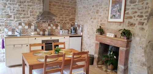 Lignieres-OrgeresDe La Terre Farm Stay的厨房配有桌椅和壁炉。