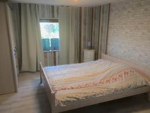 石勒苏益格Hof Larina的一间卧室设有一张带砖墙的大床