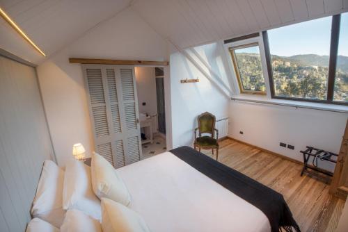圣马丁德洛斯Paraíso Casa de Montaña的一间卧室设有一张床和一个大窗户