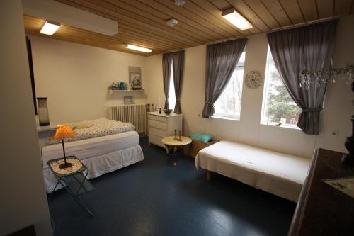 达尔维克达维克吉姆莱旅馆的一间卧室设有两张床、一张桌子和两个窗户。