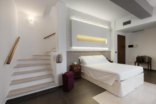 卡斯特里尼亚诺德尔卡波拉奇欧西拉酒店的卧室配有白色的床和楼梯。
