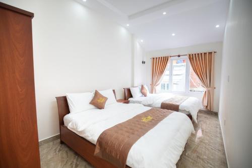 大叻Mỹ Kim Villa的一间卧室设有两张床和窗户。