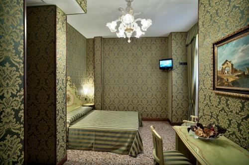 威尼斯艾尔马尔卡通酒店的酒店客房,配有一张床和吊灯