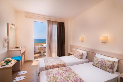 利迈纳里亚Sunray Hotel的酒店客房设有两张床,享有海景。
