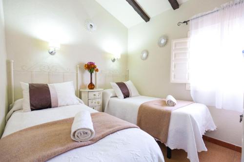 埃尔博斯克Hacienda El Molino的一间卧室配有两张带毛巾的床