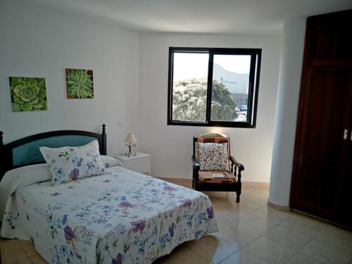 维辛达里奥UNION 64的卧室配有床、椅子和窗户。