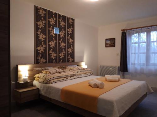 蒂萨菲赖德Eszter Vendégház的一间卧室配有一张床,上面有两条毛巾