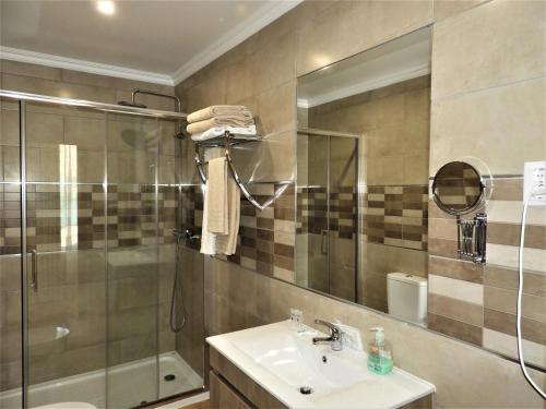 圣布拉什迪阿尔波特尔Hotel Rural Rocha da Gralheira的一间带水槽、淋浴和镜子的浴室