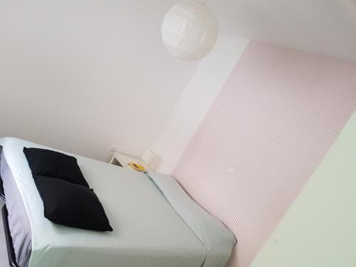 明德卢Casa Io - Djeu的卧室配有一张带黑色枕头的白色床