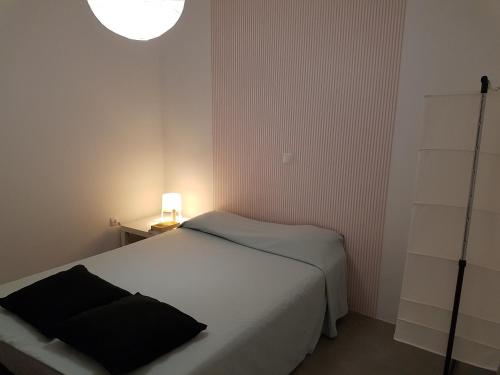 明德卢Casa Io - Djeu的一间小卧室,配有白色的床和一盏灯