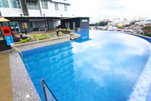 哥打巴鲁10:39 Studio @ D'Perdana Sri Cemerlang的水面上映着天空的游泳池