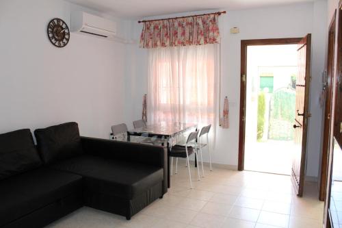 托雷维耶哈Geraneos Playa的客厅配有黑色沙发和桌子